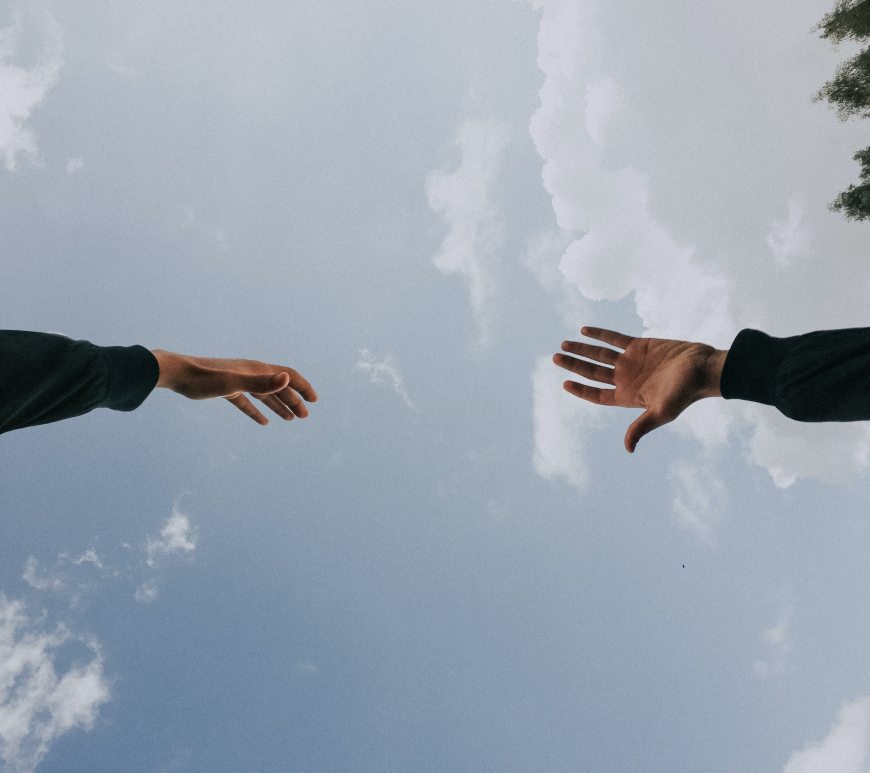 Two hands reaching out to each other in the sky